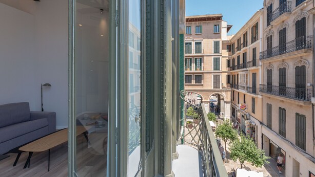 Un apartamento moderno con balcón que da a una calle histórica.