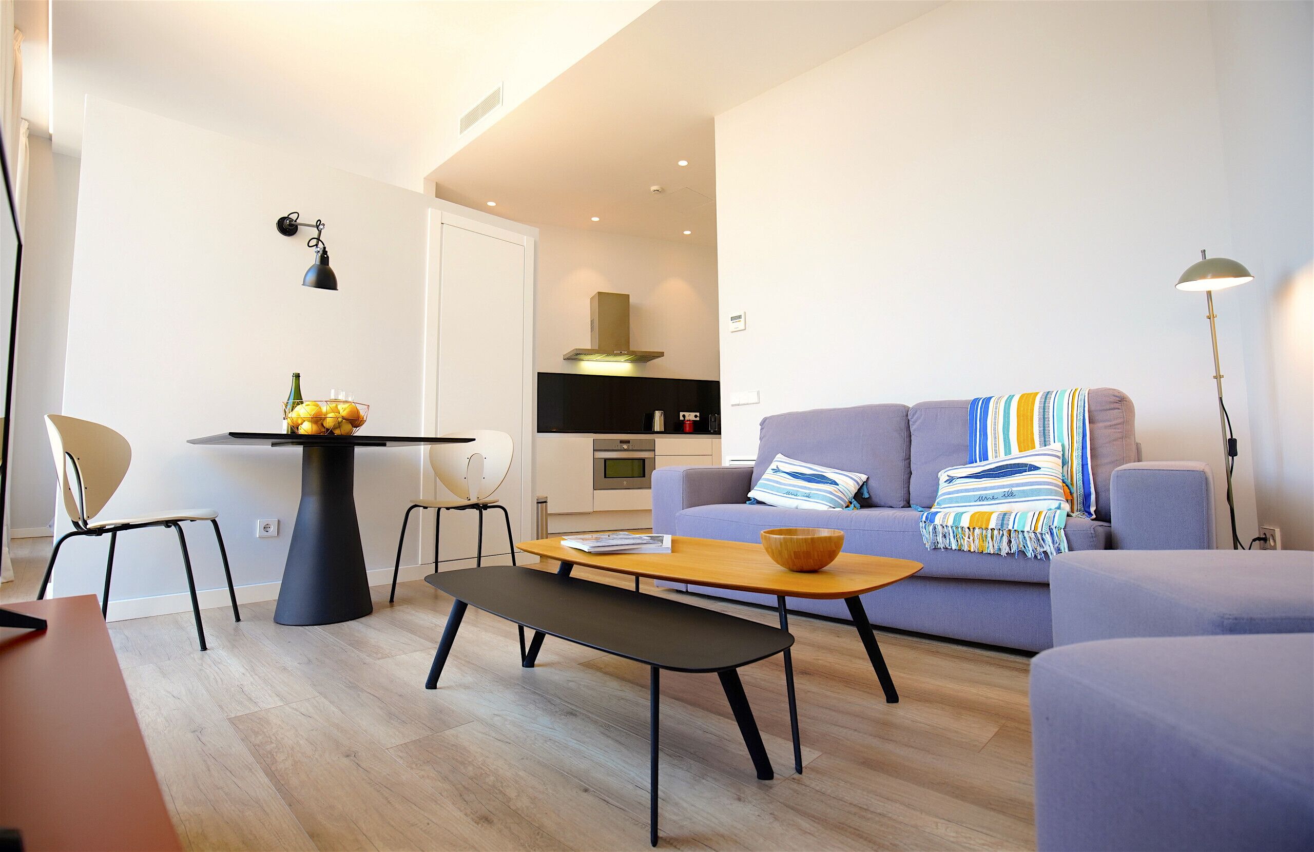 Een moderne woonkamer met een bank, een eettafel en een lange bank.