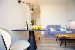 Un salon moderne avec une table à manger, un canapé et une table basse.