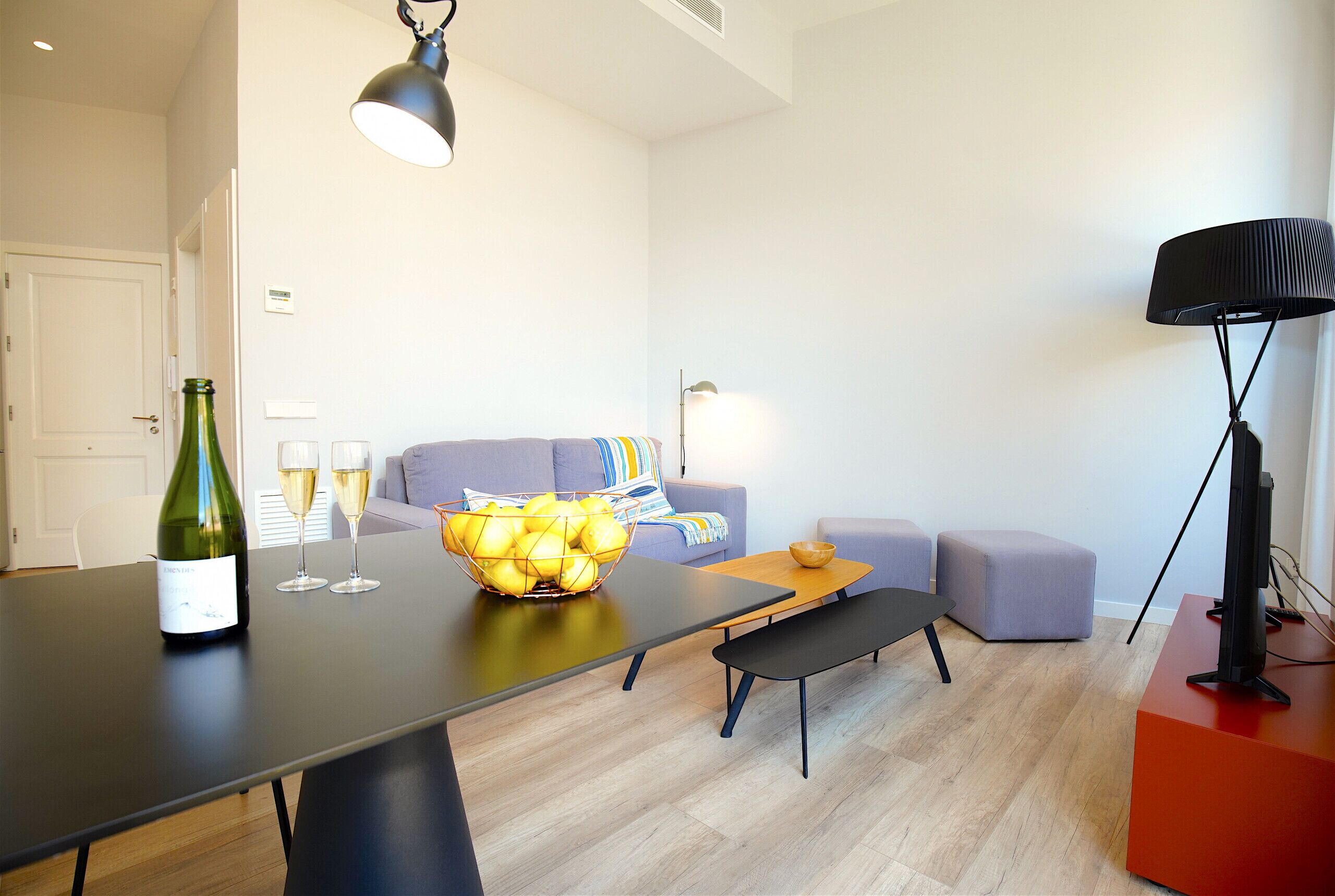 Een moderne woonkamer met een eettafel, een bank, een zitbankje en een tv-meubel.