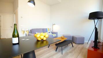 Een moderne woonkamer met een eettafel, een bank, een zitbankje en een tv-meubel.