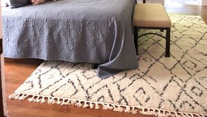 A bedroom with a bed, two chairs, a bench, a chandelier, and floral wallpaper. - Lovely Historic Home Downtown Columbus  (Columbus)