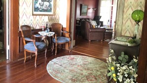 A living room with a wooden floor, a round rug, and a dining area with chairs and a table. - Lovely Historic Home Downtown Columbus  (Columbus)