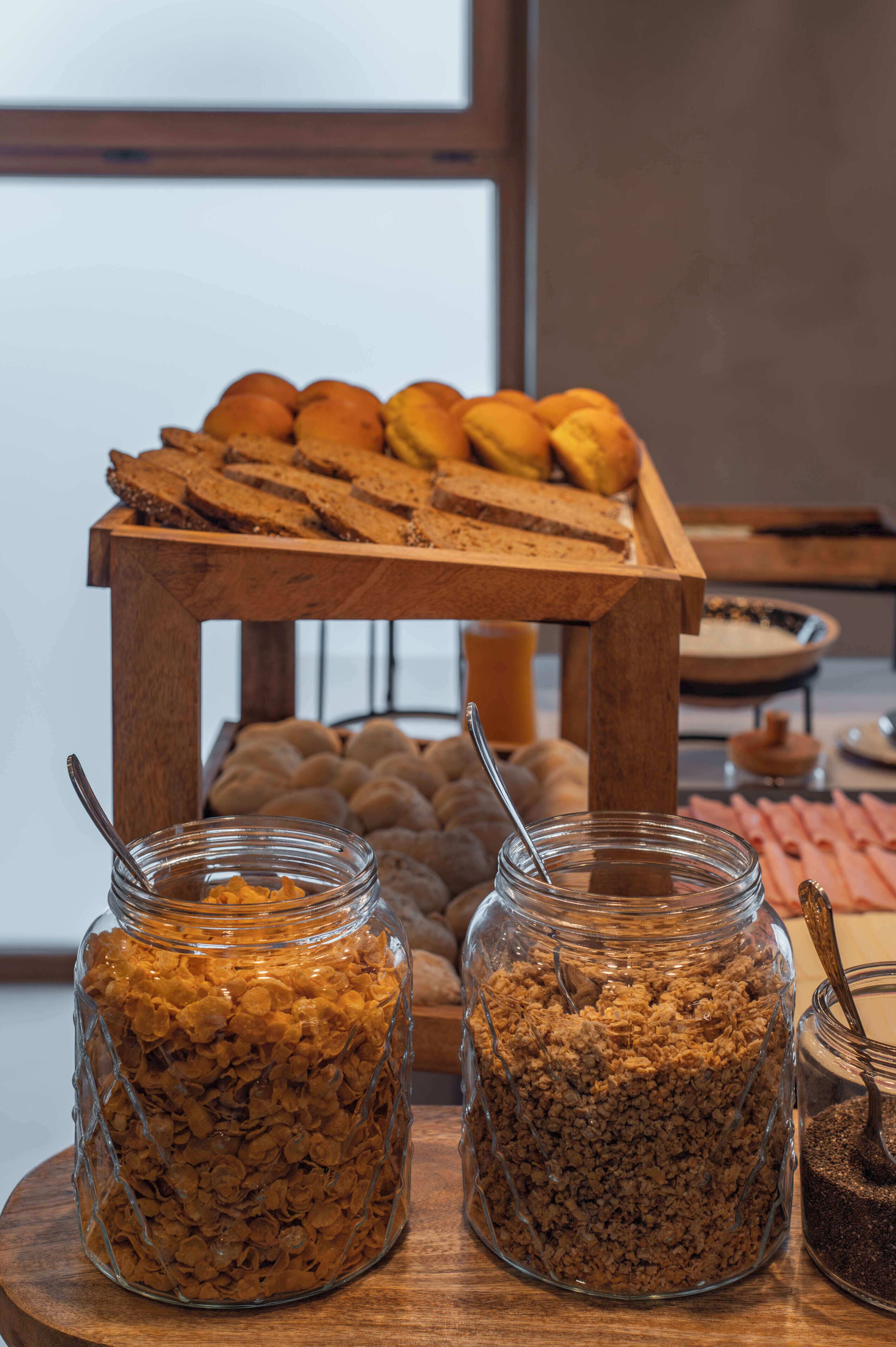 Een ontbijtbuffet met brood, muffins en cornflakes.