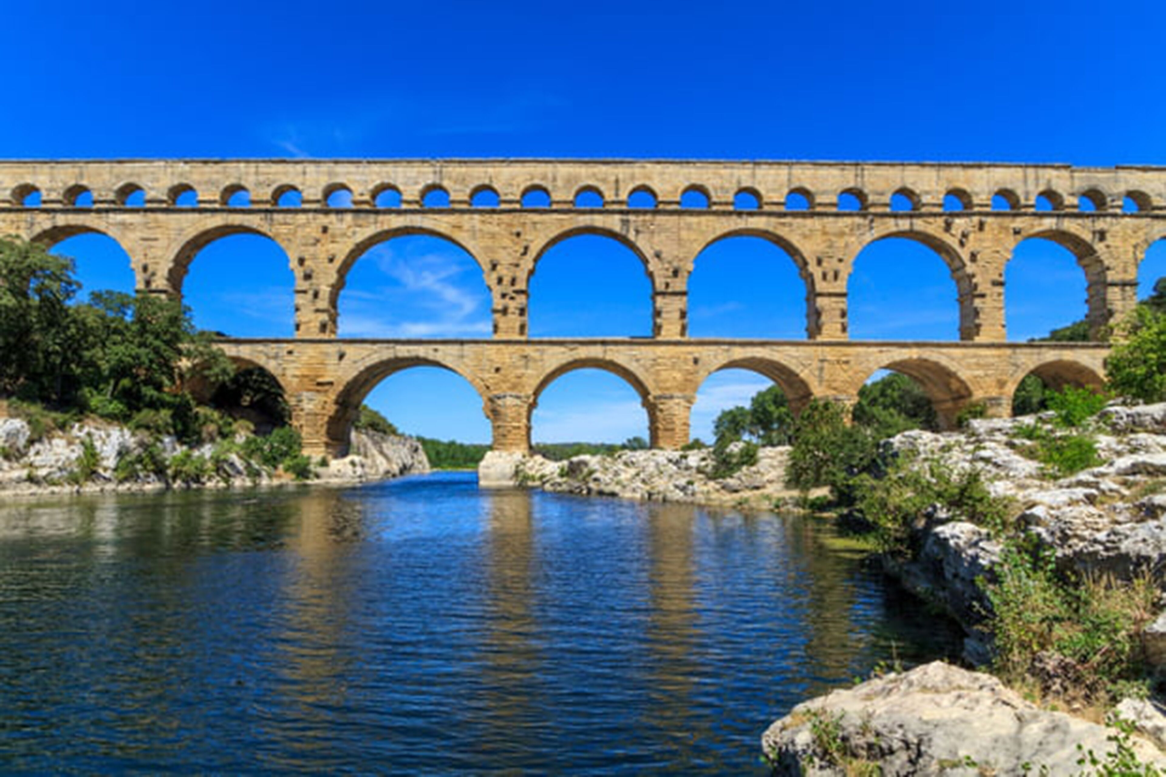 Un puente de piedra con varios arcos sobre un río.