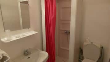 A bathroom with a white sink, mirror, and toilet.