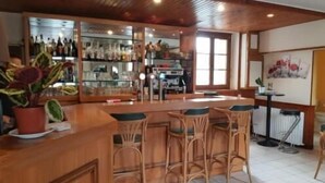 Una zona de bar con muebles de madera y una planta en maceta.