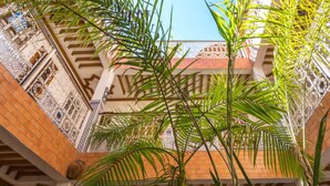 Vista interior de un edificio con detallados trabajos en azulejos en las paredes y el techo, y una escalera que sube.