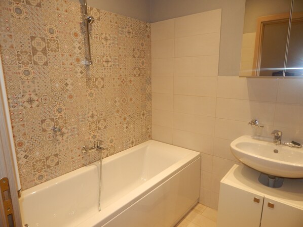 A bathroom with a bathtub, a sink, and a mirror. - Guest House Berzefi (Bergeggi)