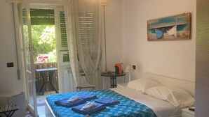 Una camera da letto con due letti, un quadro e vista dalla finestra.