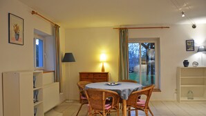 Un comedor con una mesa, sillas, una lámpara y vistas por una ventana.