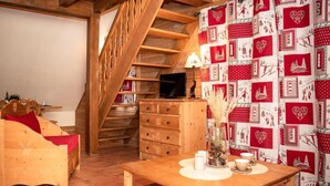 A cozy room with a wooden staircase, a wooden table with candles, and a red and white patterned curtain. - 2nd floor, balcony, parking, tv, ski locker, 38m², Pra Loup (Uvernet-Fours)