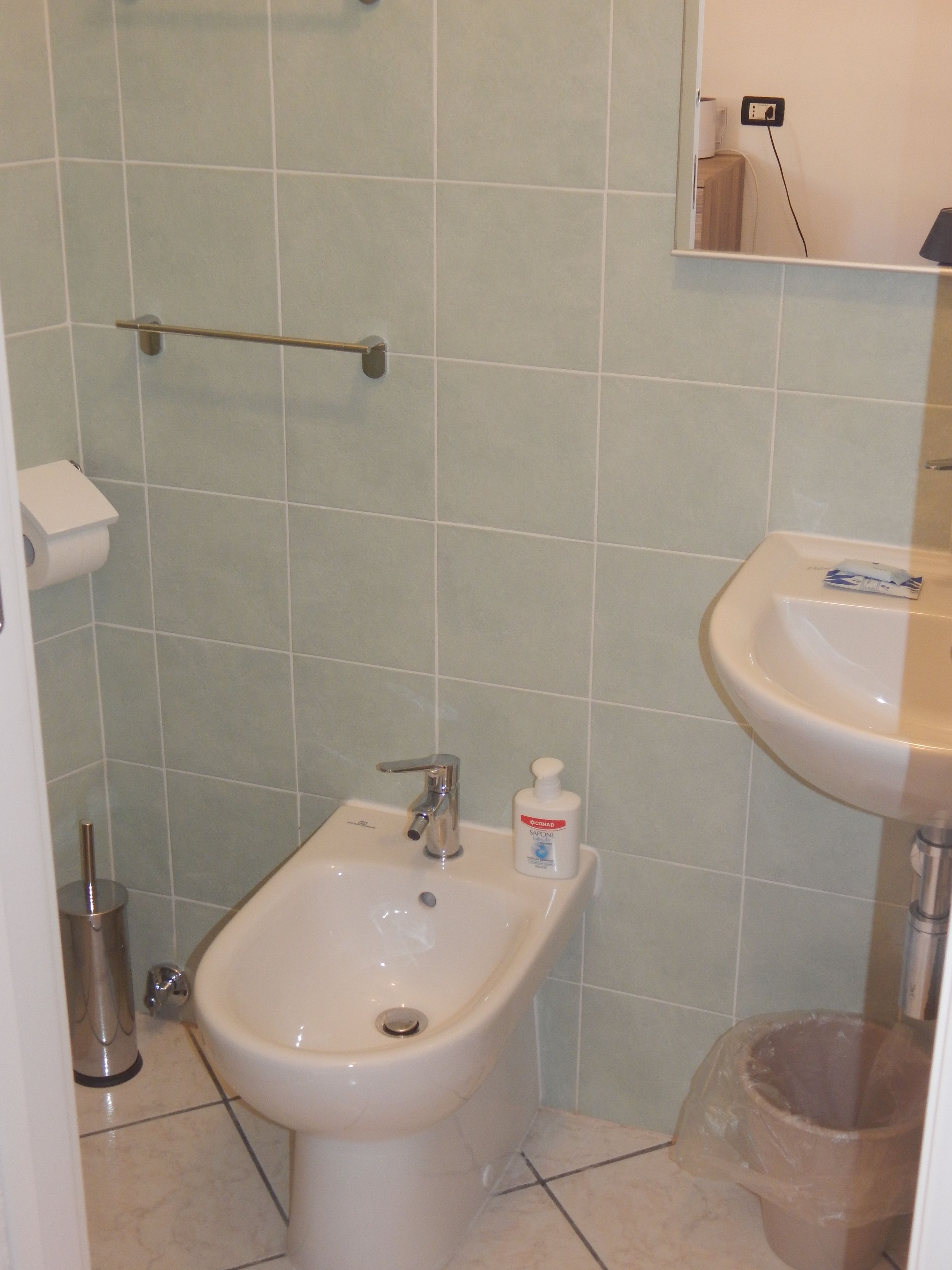 A bathroom with a bidet, a sink, and a toilet.