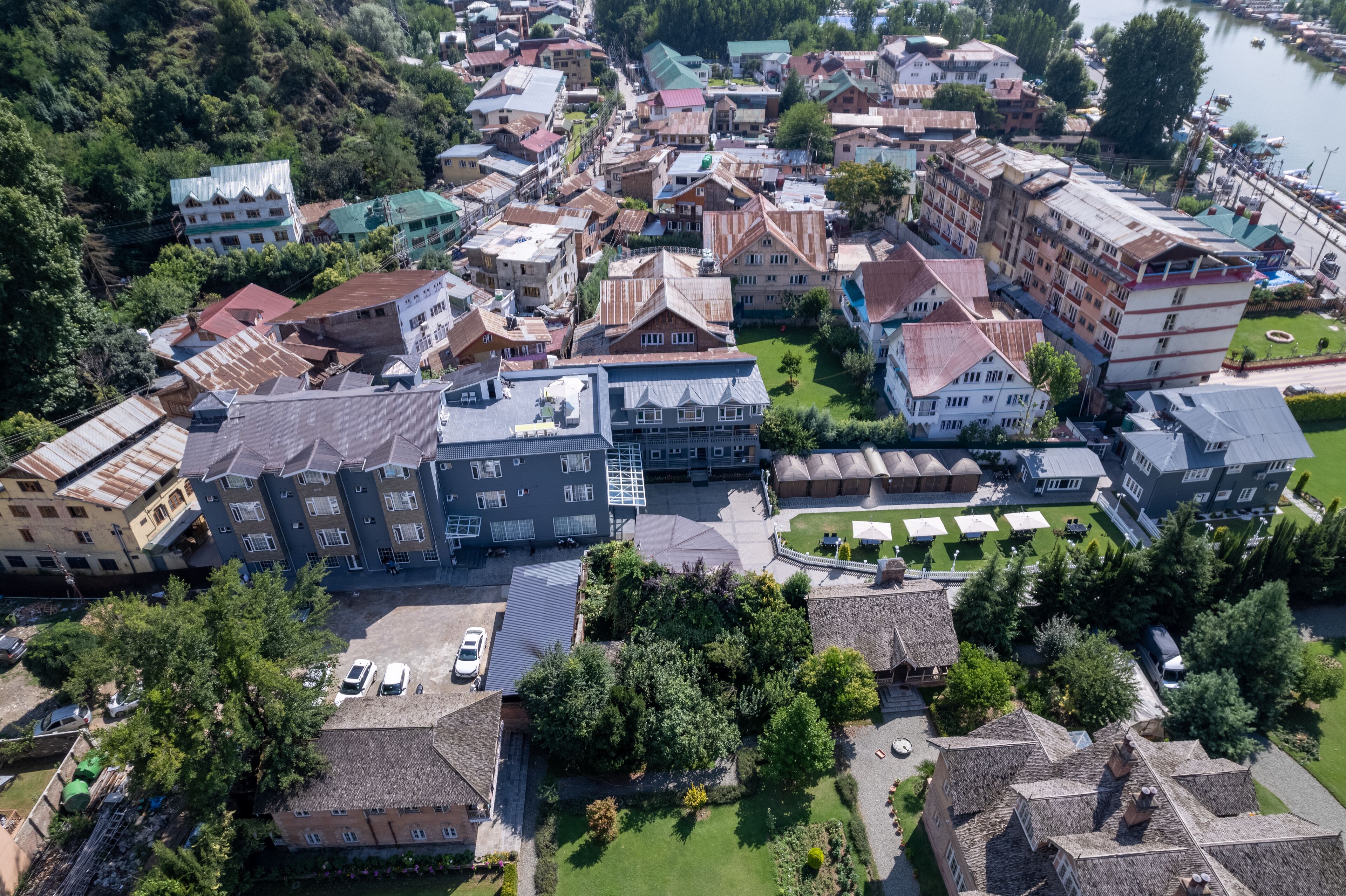 Vista aérea de una zona residencial con varios edificios, algunos con techos planos y otros con techos inclinados. Se observan entradas de vehículos y áreas de estacionamiento.