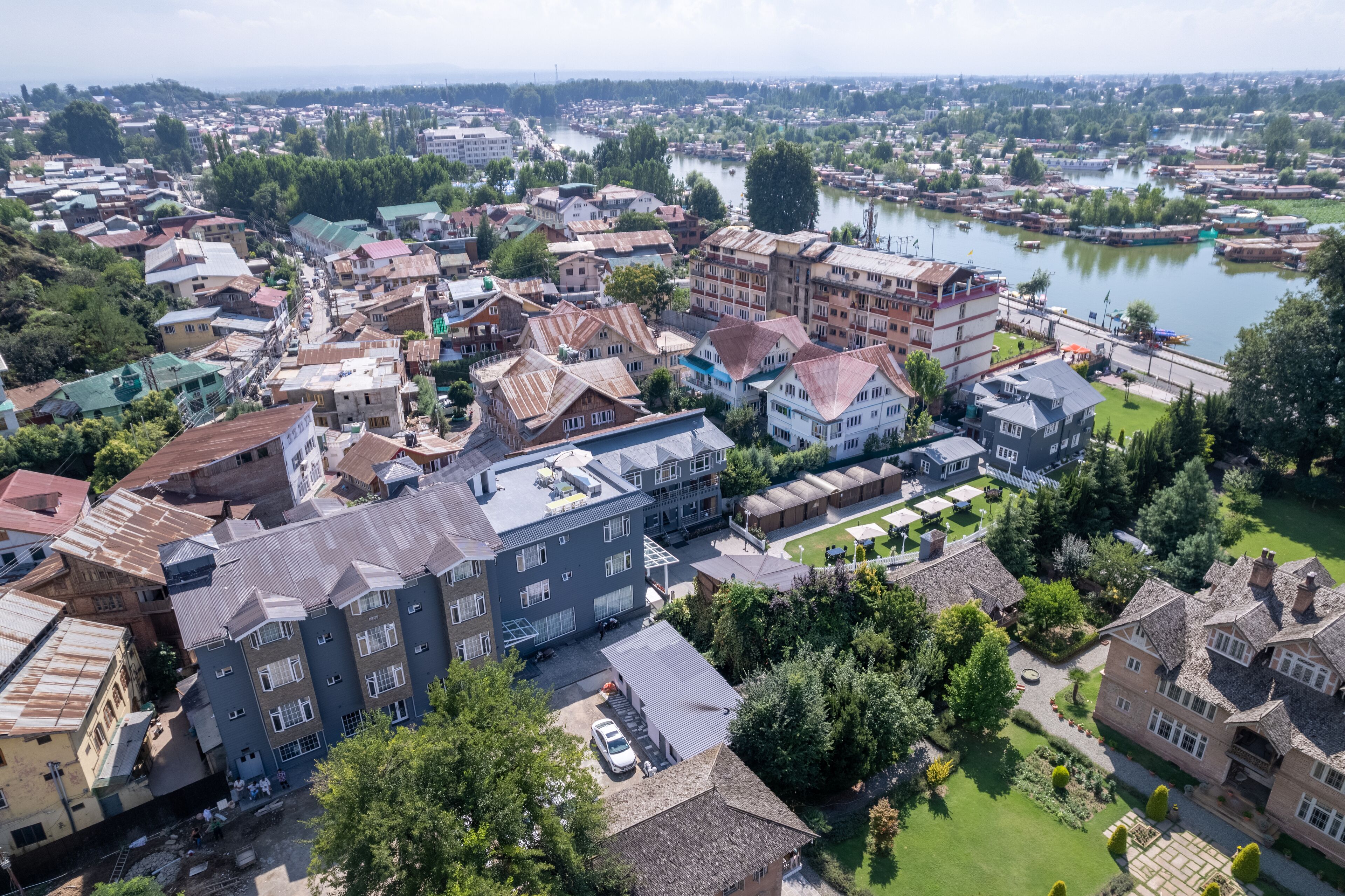 Vista aérea de un pueblo con edificios, un río y zonas verdes.