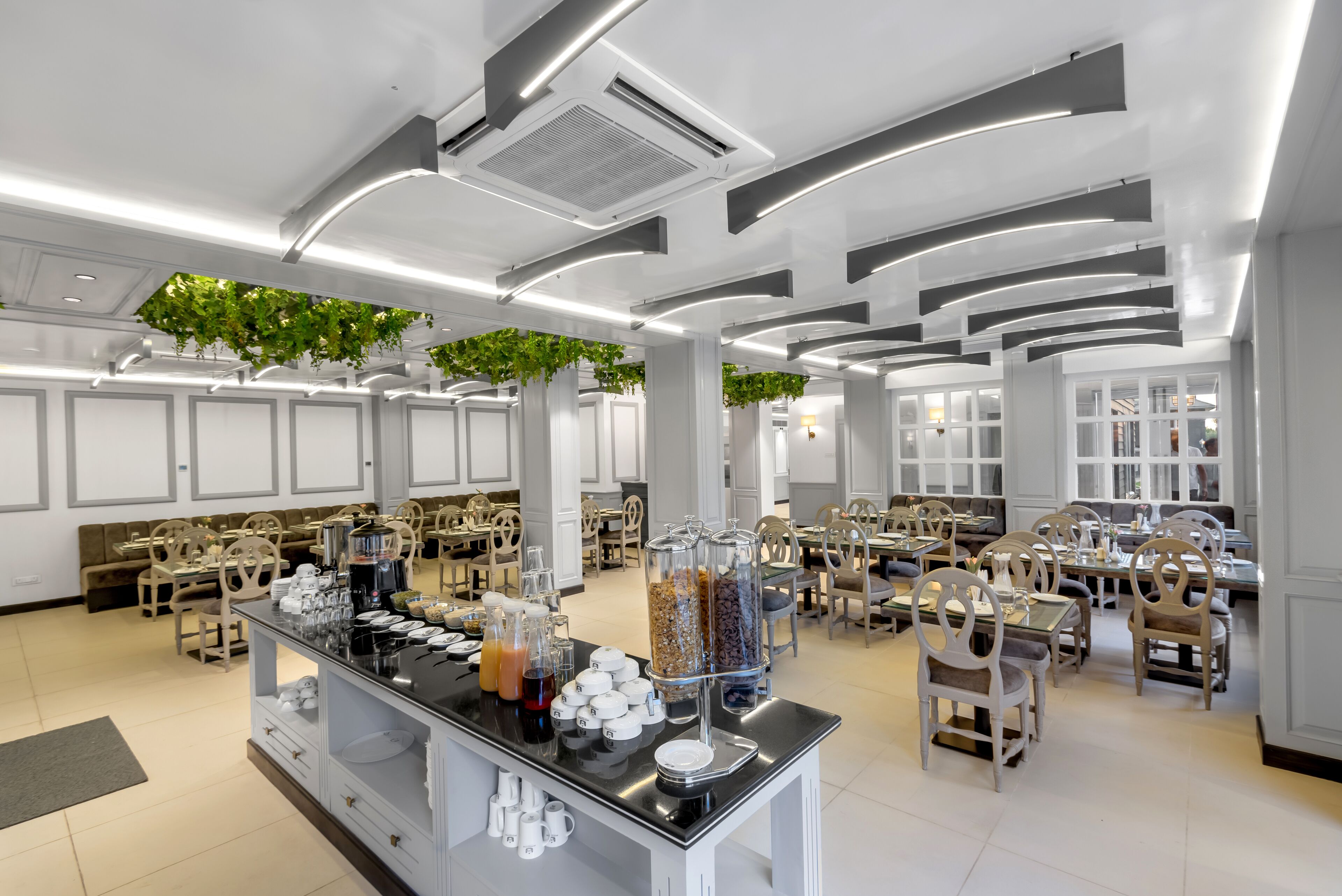 A modern dining area with a buffet setup, including various food items and beverages.