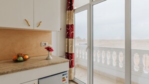 A kitchen with a view of a balcony and a desert landscape. - Desert Moon (Giza)