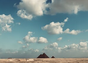 A desert landscape with pyramids under a clear sky.