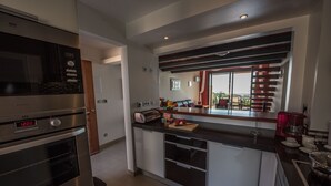 A modern kitchen with stainless steel appliances, a central island, and a view to the outdoors. - Apt. Arribas, with pool and indoor heated pool (Praia da Luz)