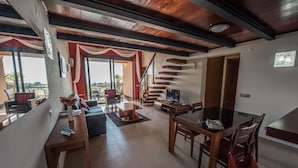 A modern living room with a staircase, a dining area, and a view of the outdoors. - Apt. Arribas, with pool and indoor heated pool (Praia da Luz)