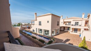 A modern residential building with a swimming pool, a covered patio, and a view of the surrounding neighborhood. - Apt. Arribas, with pool and indoor heated pool (Praia da Luz)