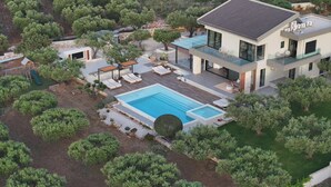 Una casa moderna de dos pisos con piscina, mobiliario exterior y jardín ajardinado.
