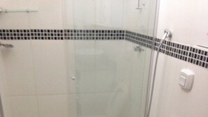 Un baño con cabina de ducha de vidrio, inodoro y lavamanos con encimera de granito.