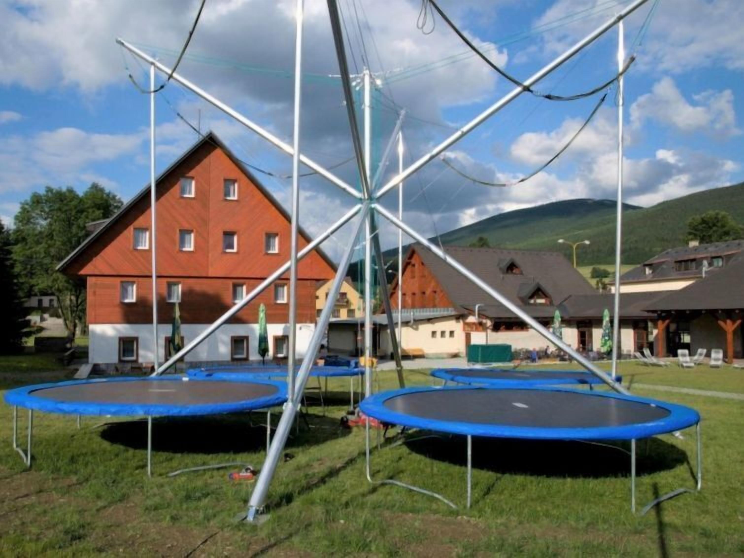 Una zona residencial con varias casas, una estructura metálica grande y tres trampolines.
