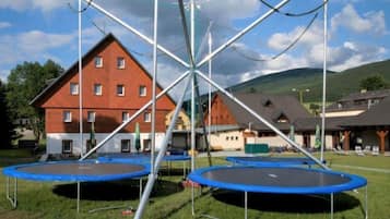 Una zona residencial con varias casas, una estructura metálica grande y tres trampolines.