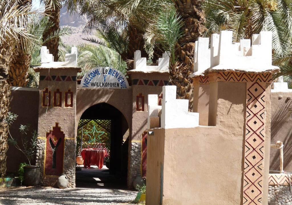 A traditional Moroccan gate with a sign welcoming visitors.