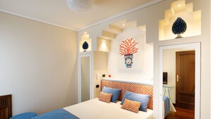 Une chambre à coucher moderne avec un grand lit, une table de chevet et un téléviseur fixé au mur.
