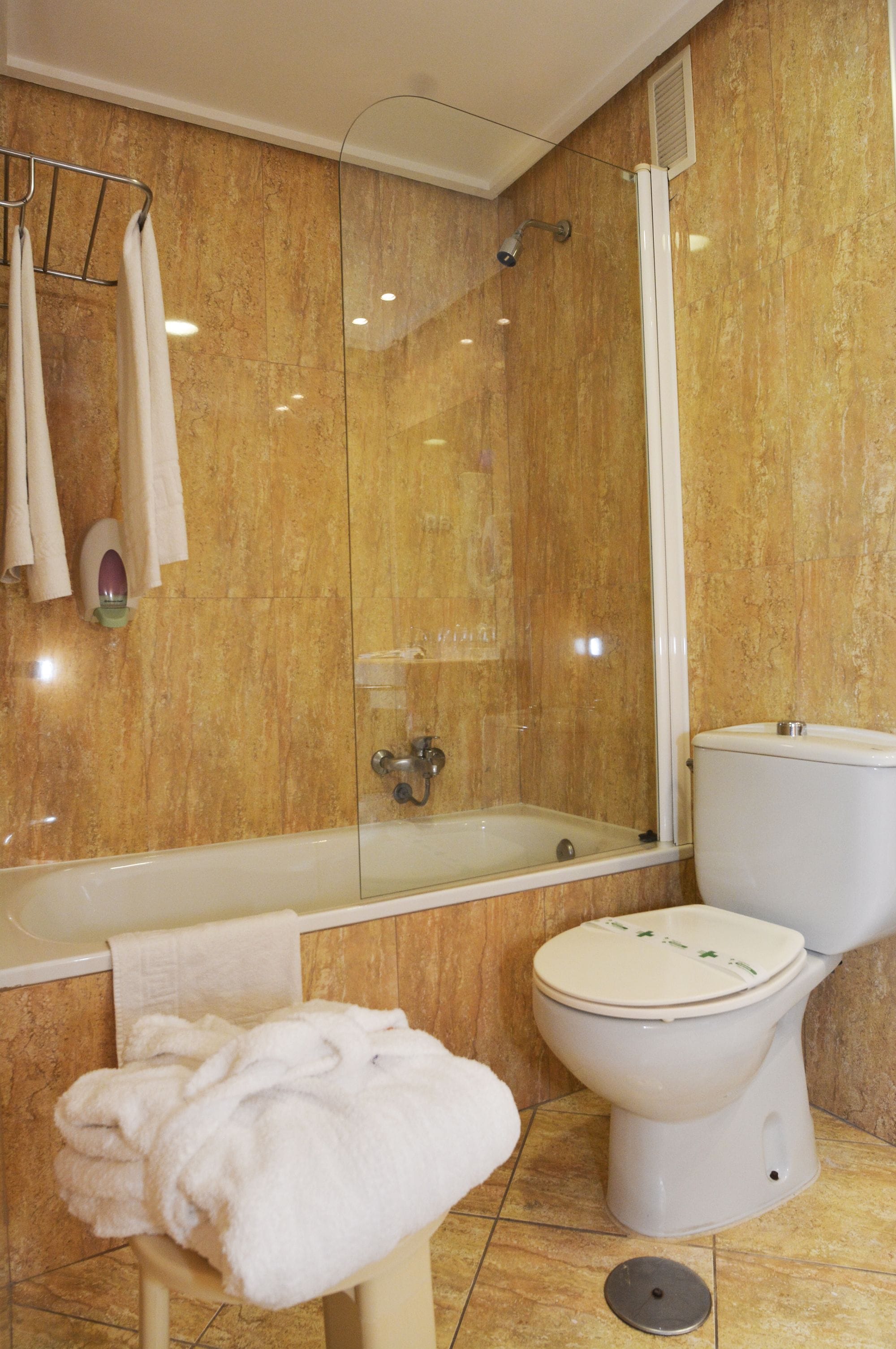 A bathroom with a bathtub, toilet, and a glass-enclosed shower.