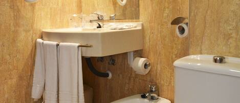 Ein Badezimmer mit Waschbecken, Bidet, Toilette und Handtuchhalter.