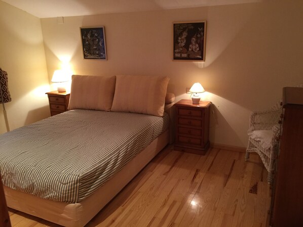 A bedroom with a bed, two nightstands with lamps, a chair, and two wall-mounted paintings. - Casa Alaya (6 people) full rental (Bailo)
