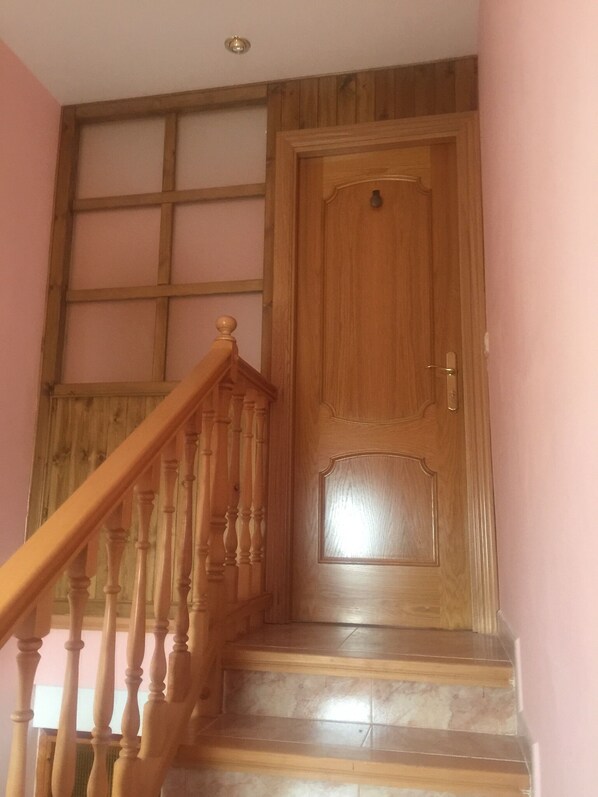 A wooden staircase with a handrail leading to a wooden door with a handle and a keyhole. - Casa Alaya (6 people) full rental (Bailo)