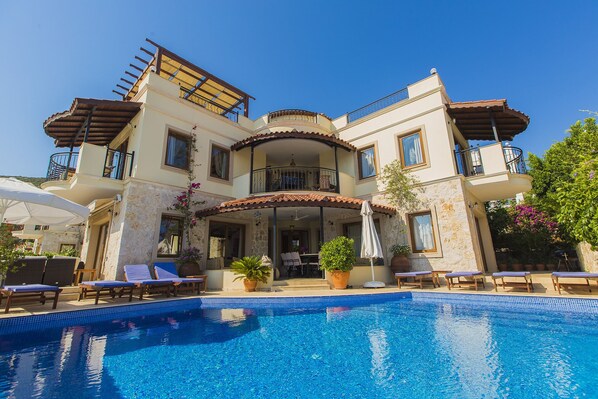 Una piscina con borde infinito, una piscina climatizada, tumbonas