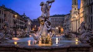 Una maestosa fontana con statue in una piazza storica, circondata da architettura classica.