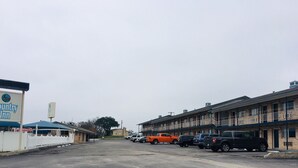 A Country Inn with a parking lot and several vehicles.