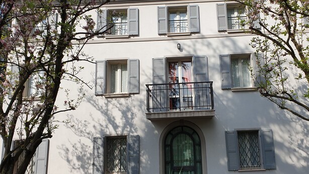 A building with multiple windows, some with shutters, and a balcony with a railing. - Nuovo Hotel Sporting (Campagnola Emilia)