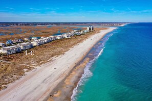 An aerial view of a coastal hotel with a beachfront, sandy beach, and ocean.