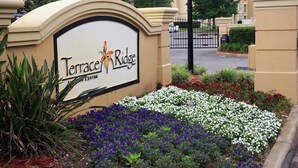 A sign for Terrace Ridge with a landscaped garden in front. - Your next magical getaway! Spacious 3 bedroom, 2 bath condo in gated community. (Davenport)
