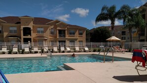 A swimming pool with lounge chairs and a flag. - Your next magical getaway! Spacious 3 bedroom, 2 bath condo in gated community. (Davenport)