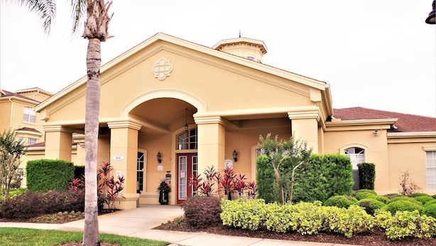 A two-story building with a symmetrical facade, a central entrance with an arch, and a small balcony on the second floor. - Your next magical getaway! Spacious 3 bedroom, 2 bath condo in gated community. (Davenport)