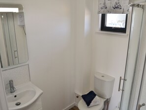 A bathroom with a sink, toilet, and shower.
