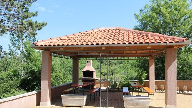 A covered outdoor area with a brick-tiled roof, a grill, and picnic tables. - Apartment Dudovic Damir A2 nr 1 (Silo - island Krk)