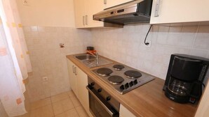 A kitchen with a stove, oven, sink, and coffee maker. - Apartment Dudovic Damir A2 nr 1 (Silo - island Krk)
