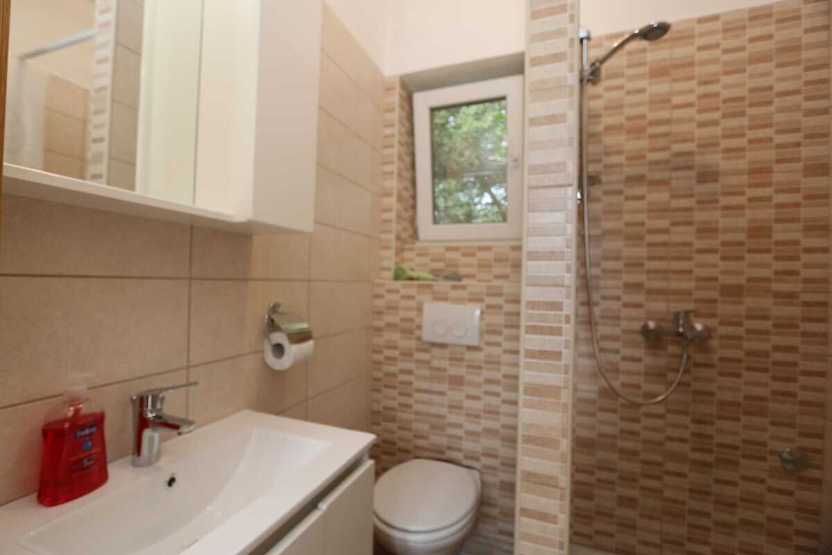 A bathroom with a sink, toilet, and shower.
