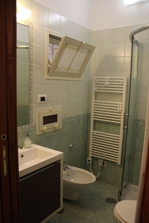 Een douche, een haardroger, een bidet, handdoeken