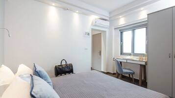 Une chambre d’hôtel comprenant un lit, un bureau, une chaise et une armoire.