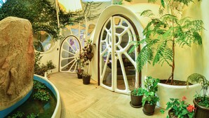 A modern interior with arched doorways, potted plants, and a large rock centerpiece. - Wifala Harmony Hotel (Urubamba)